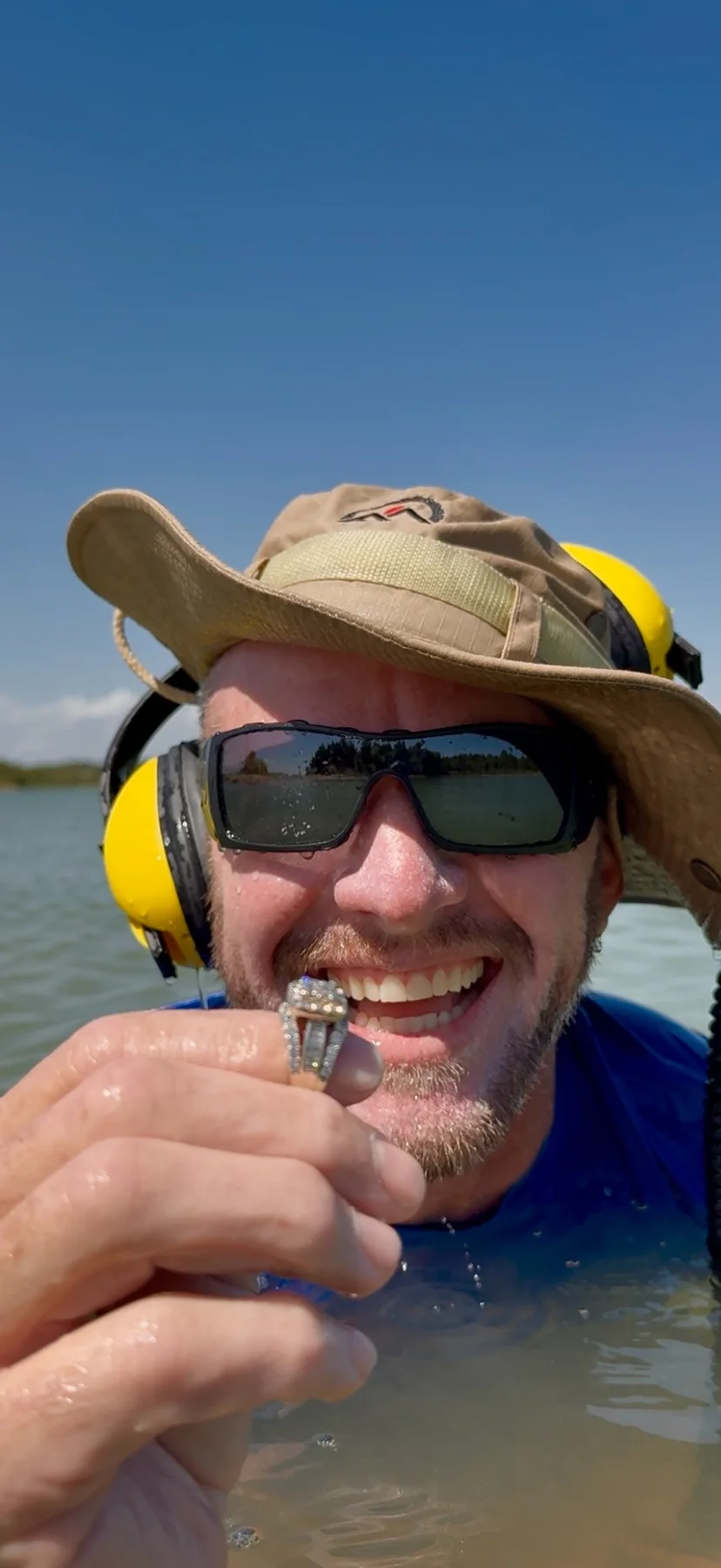 Derik holding a recovered diamond wedding ring in an Oklahoma lake
