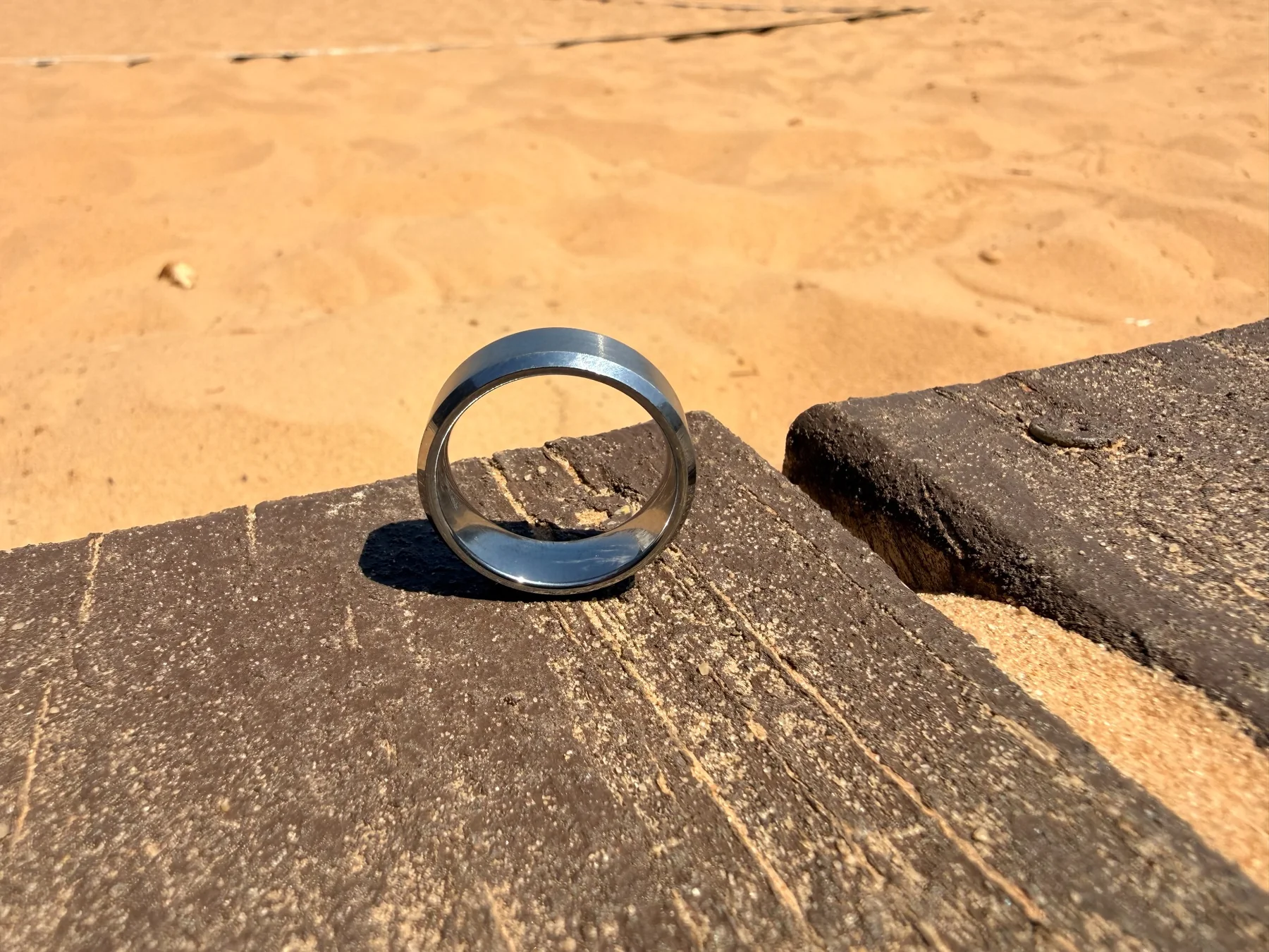 Recovered tungsten wedding ring beside the sand volleyball court